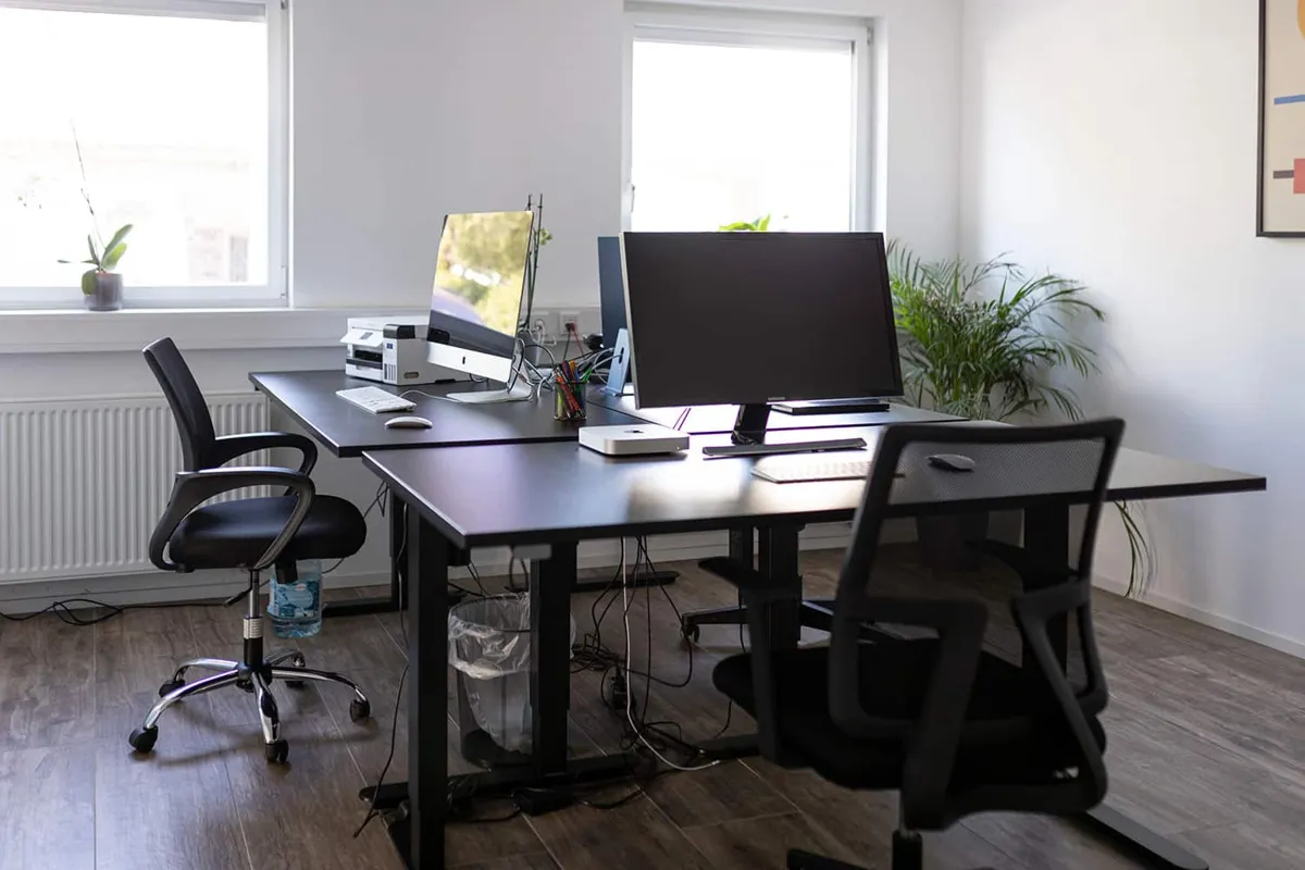 Weitere Arbeitsplätze mit Bildschirmen und Bürostühlen im neuen Büro in Völklingen