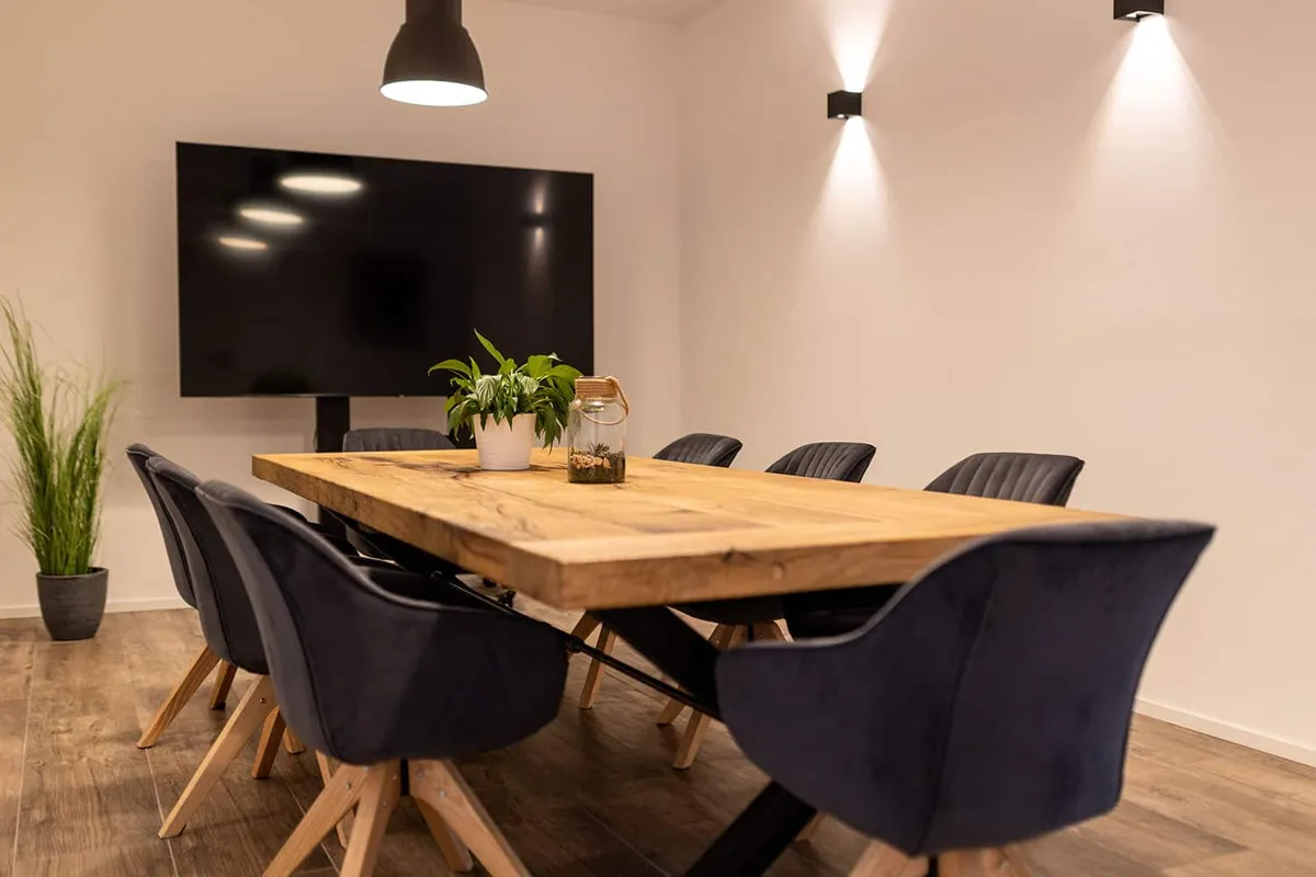 Besprechungsraum von marketing thom in Völklingen mit Holztisch und Bildschirm