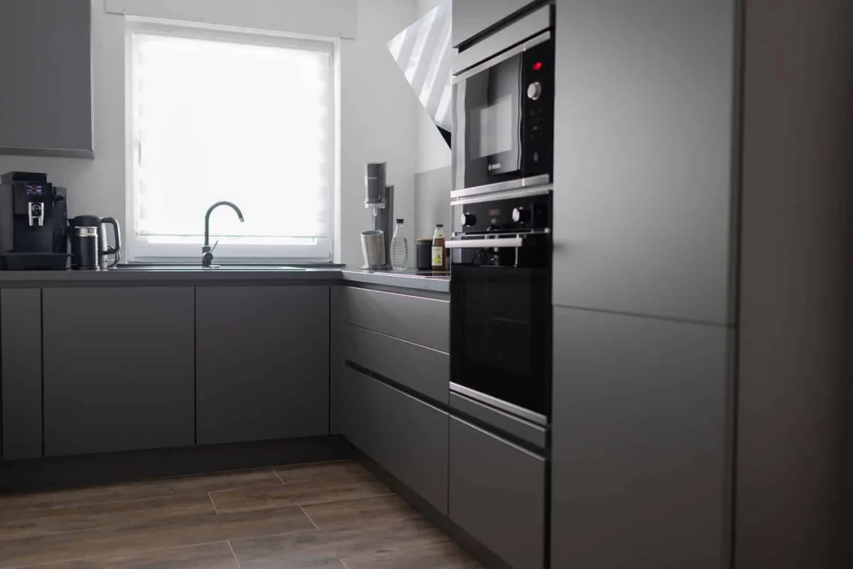 Küche in Anthrazit mit Kaffeemaschine und Einbaubackofen im Büro von marketing thom