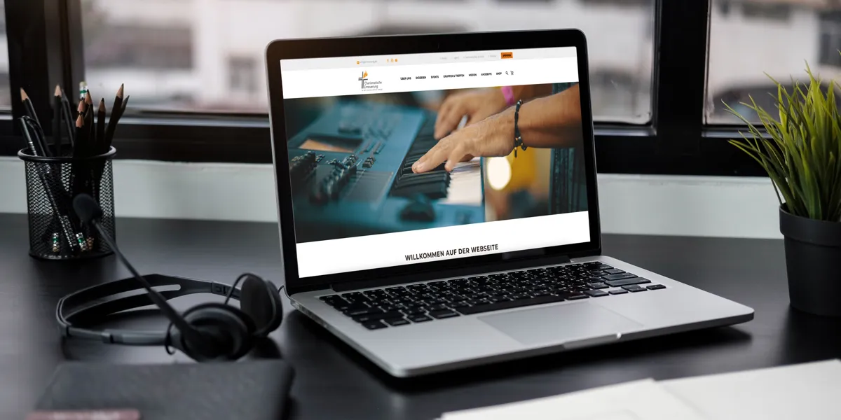 Website der Charismatischen Erneuerung in der Katholischen Kirche auf einem Laptop am Arbeitsplatz