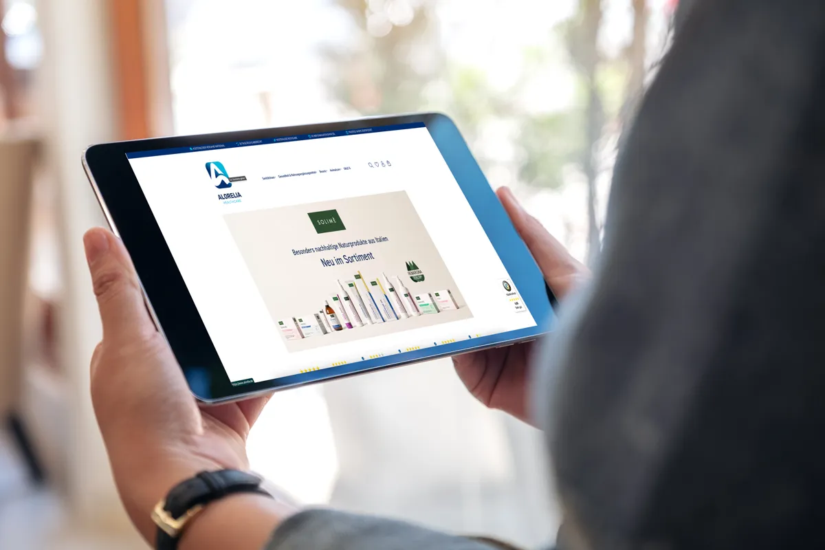 Website von Alorelia Healthcare mit Produktübersicht auf einem Tablet in der Hand