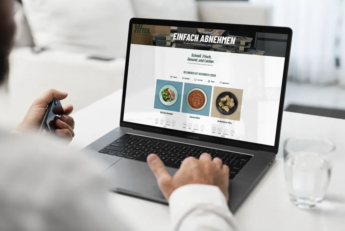Onlineshop von EATFITTER mit „Einfach abnehmen“ und Gerichten auf einem Laptop