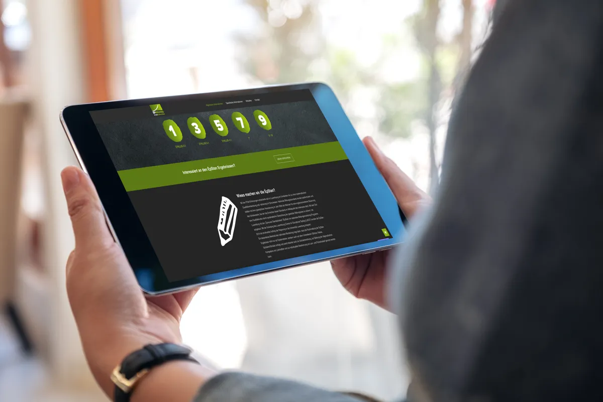Website von ÉPSTAN aus Luxemburg in dunklem Design auf einem Tablet in der Hand