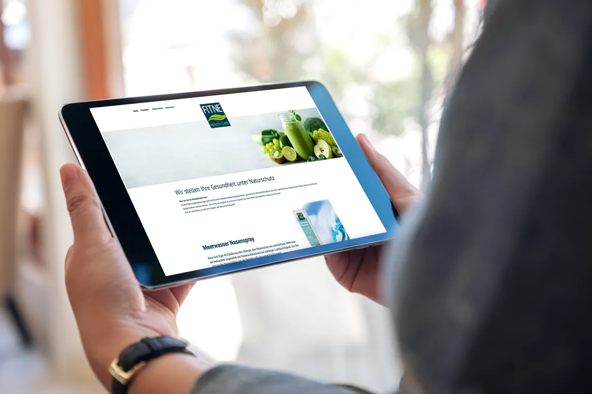 WordPress-Website von FITNE mit Gemüse-Motiv auf einem Tablet in der Hand