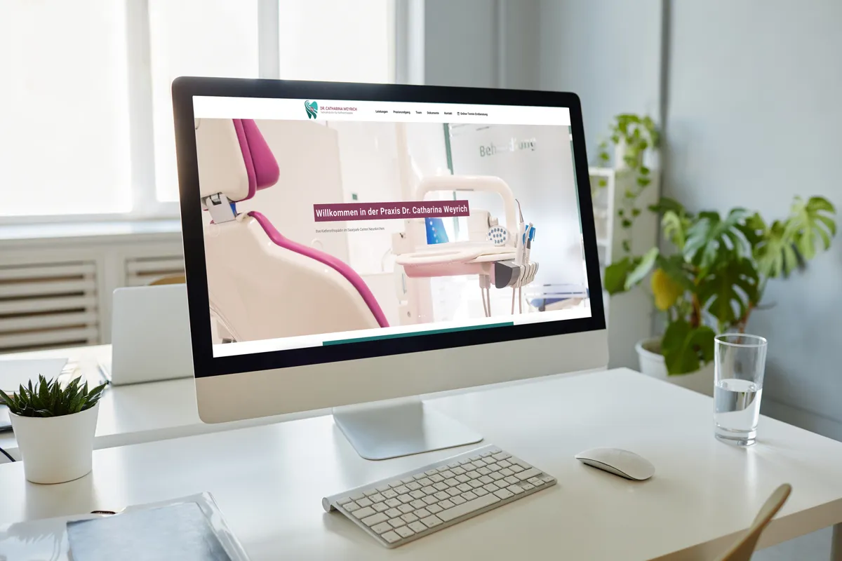 Website der Kieferorthopädie Dr. Catharina Weyrich mit Behandlungsstuhl auf einem Desktop-Bildschirm