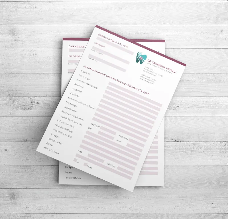 Formulare im Corporate Design der Kieferorthopädie Dr. Catharina Weyrich auf einem Holztisch