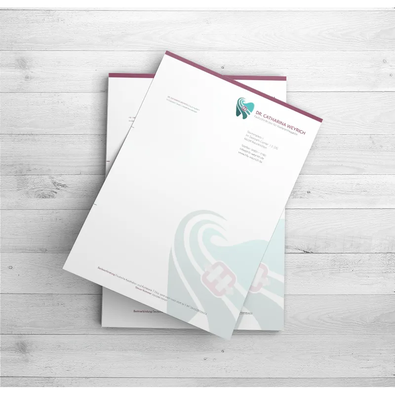 Briefpapier der Kieferorthopädie Dr. Catharina Weyrich auf hellem Holzuntergrund