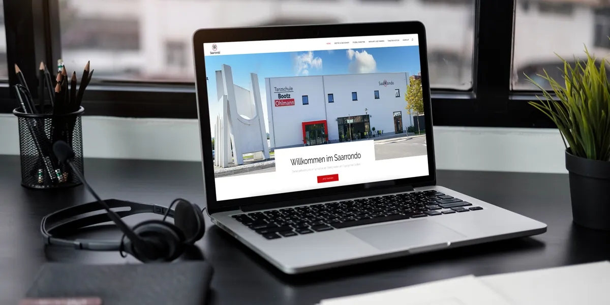 Website der Eventlocation Saarrondo mit Gebäudefoto auf einem Laptop am Fenster