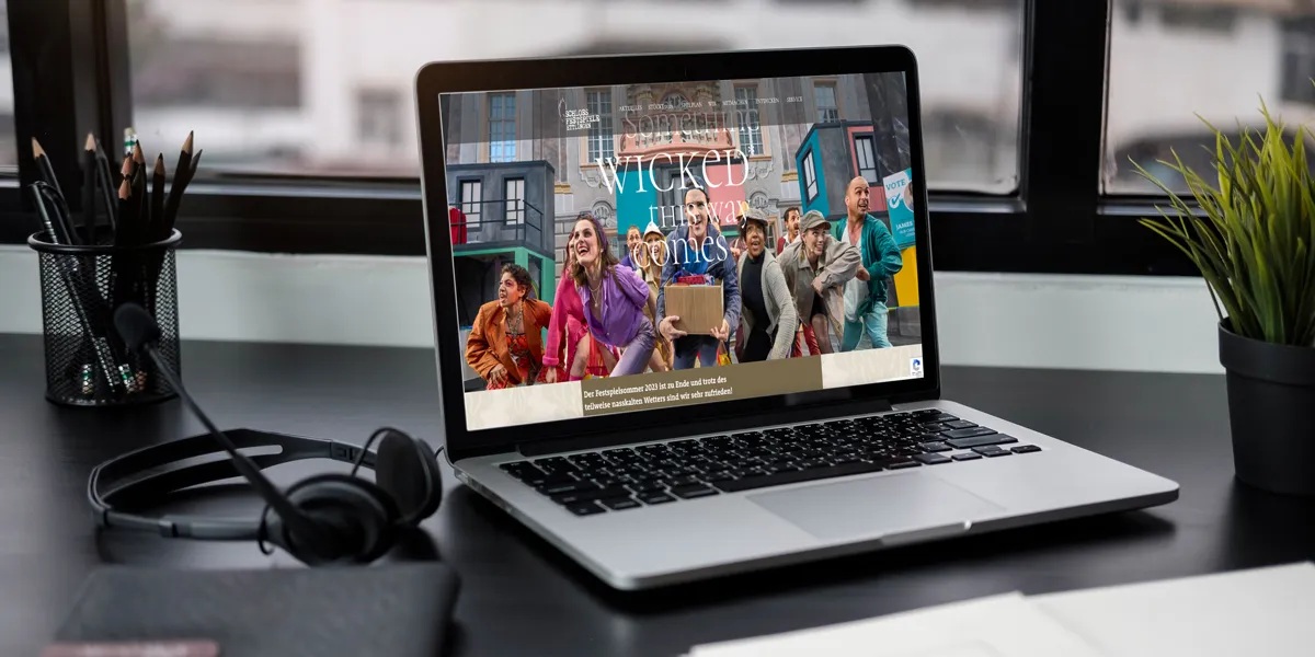 Website der Schlossfestspiele Ettlingen mit Ensemblefoto auf einem Laptop