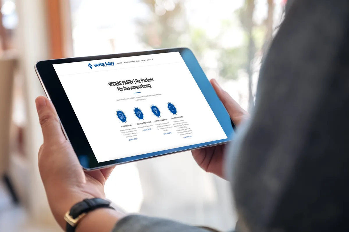 Website von werbe fabry aus Saarbrücken auf einem Tablet in den Händen einer Person