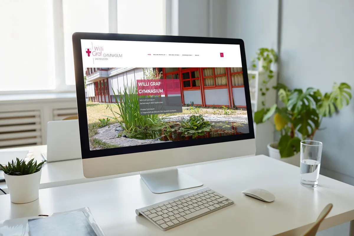 Website der Willi-Graf-Schulen Saarbrücken mit Schulgebäude auf einem iMac