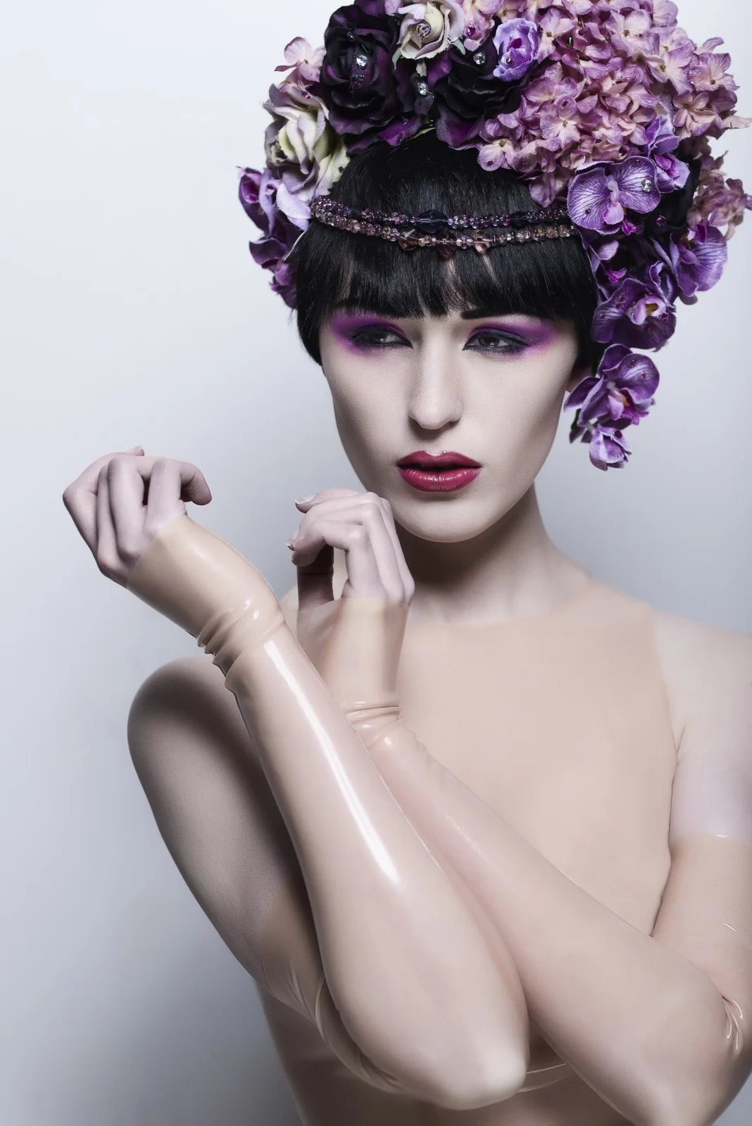 Beauty-Aufnahme im Studio: Model mit violettem Blumenkopfschmuck und violettem Make-up