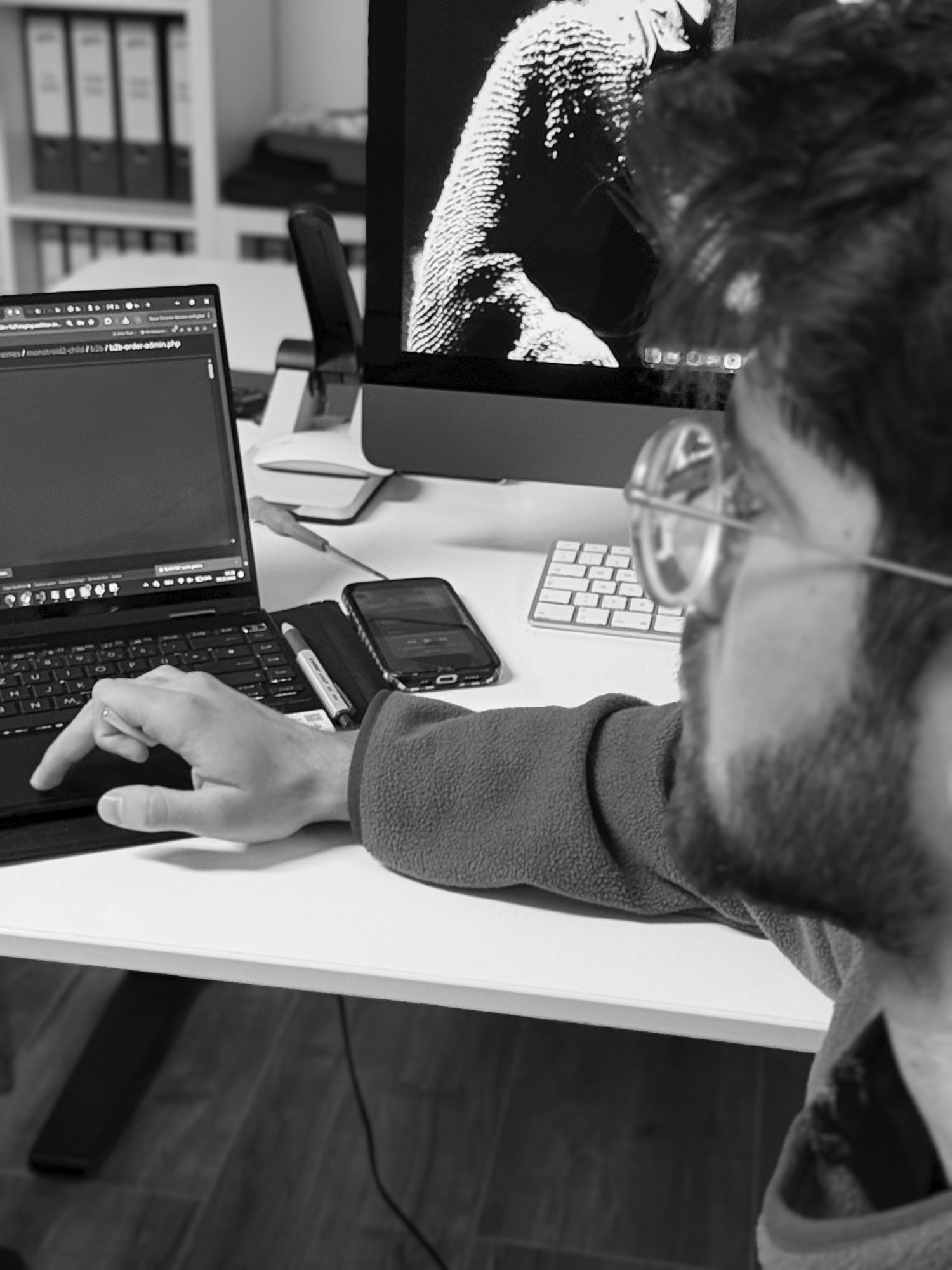 Programmierung einer Website im Büro von marketing thom: Entwickler am Laptop vor zweitem Bildschirm
